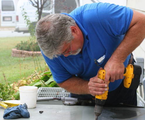 Tradesperson repairing an AC unit